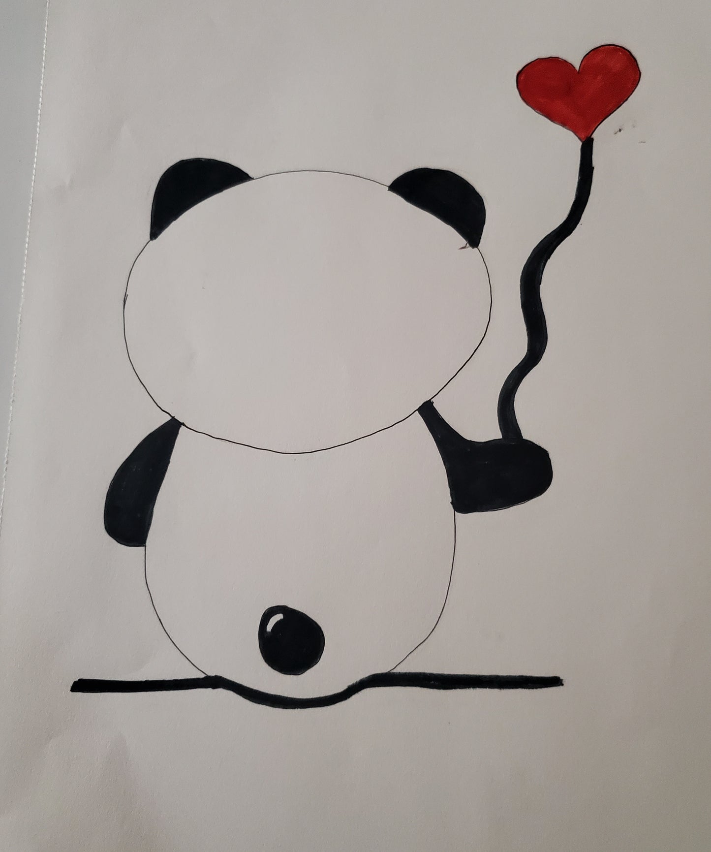A panda holding a herat balloon